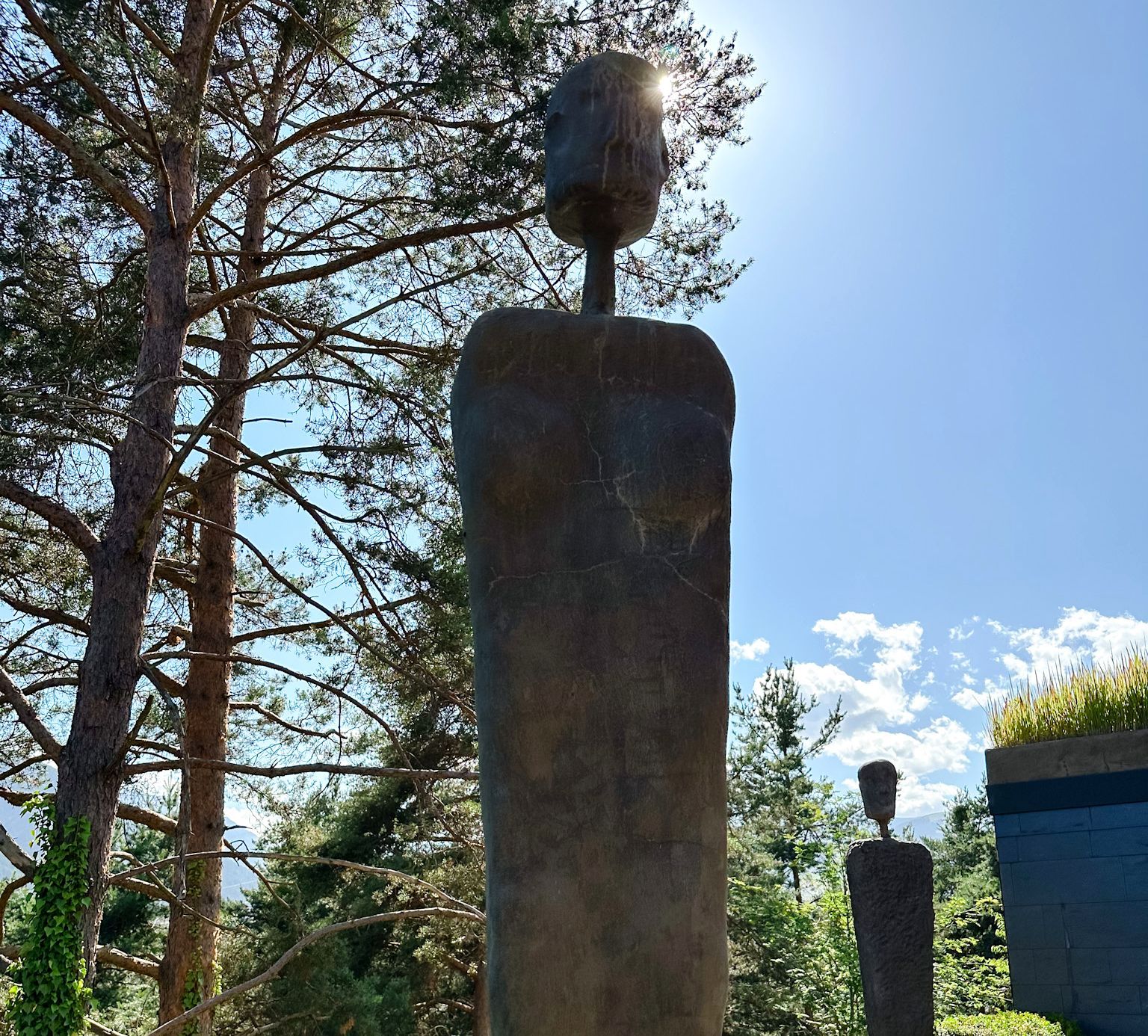 Kopf einer Figur vor Himmel und Bäumen